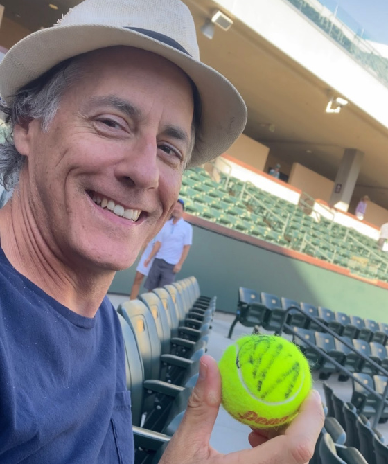 Gary holding signed tennis ball